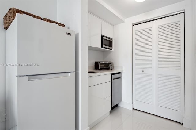 791 Crandon Blvd Unit C.851, Key Biscayne, FL 33149 - kitchen featuring stainless steel appliances, white cabinets, light tile patterned flooring, light countertops, and modern cabinets