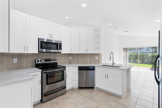 324 NW 107th Ave, Pembroke Pines, FL 33026 - kitchen featuring appliances with stainless steel finishes, open shelves, a peninsula, lofted ceiling, and backsplash