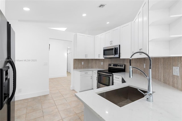 324 NW 107th Ave, Pembroke Pines, FL 33026 - kitchen featuring stainless steel appliances, open shelves, white cabinets, backsplash, and light stone counters