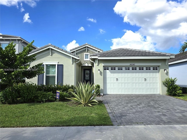 16190 Melogold Dr, Loxahatchee, FL 33470 - single story home featuring an attached garage, decorative driveway, stucco siding, a tiled roof, and a front yard