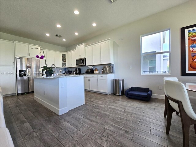 16190 Melogold Dr, Loxahatchee, FL 33470 - kitchen featuring stainless steel appliances, recessed lighting, white cabinetry, dark wood-style floors, and a center island with sink