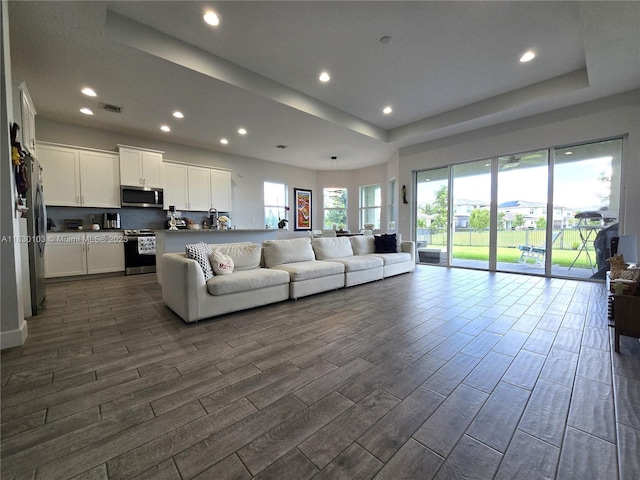 16190 Melogold Dr, Loxahatchee, FL 33470 - living room with dark wood-style floors, recessed lighting, and a tray ceiling