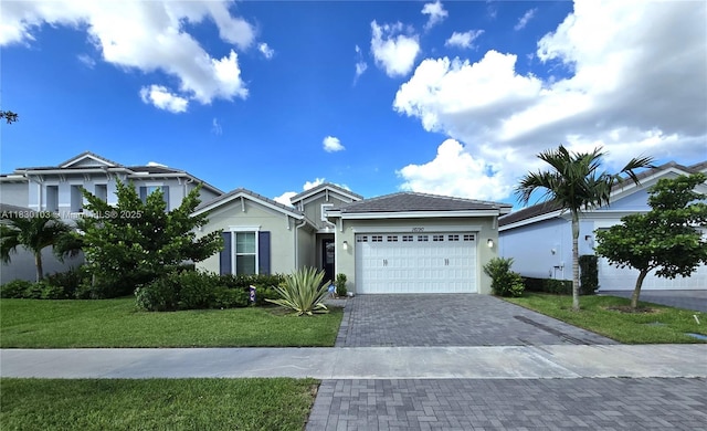 16190 Melogold Dr, Loxahatchee, FL 33470 - view of front of home with a garage, decorative driveway, a front yard, stucco siding, and a tile roof