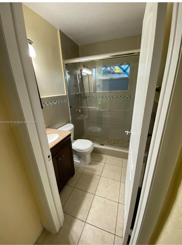 6433 SW 22nd St, Miramar, FL 33023 - bathroom with a shower stall, vanity, tile patterned floors, a textured ceiling, and tile walls