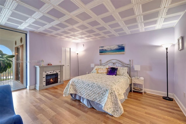 3650 Environ Blvd Unit 502, Lauderhill, FL 33319 - bedroom with access to outside, light wood-style flooring, an ornate ceiling, and a warm lit fireplace