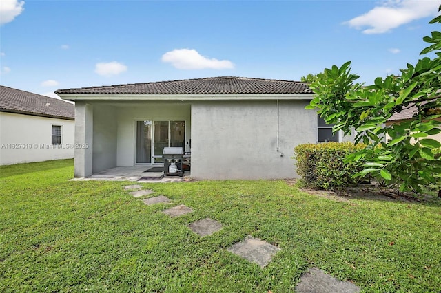 7095 E Tropical Way, Plantation, FL 33317 - back of house with stucco siding, a lawn, a tiled roof, and a patio area
