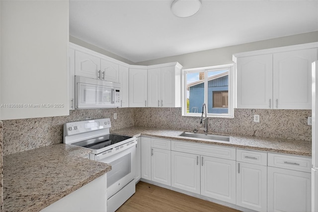 11504 SW 226th St, Miami, FL 33170 - kitchen with white appliances, white cabinets, tasteful backsplash, and light stone counters