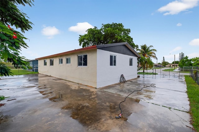 11504 SW 226th St, Miami, FL 33170 - view of side of home featuring stucco siding and a patio area