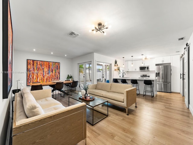 14913 SW 143rd Ct, Miami, FL 33186 - living area featuring a barn door, light wood-style floors, and recessed lighting