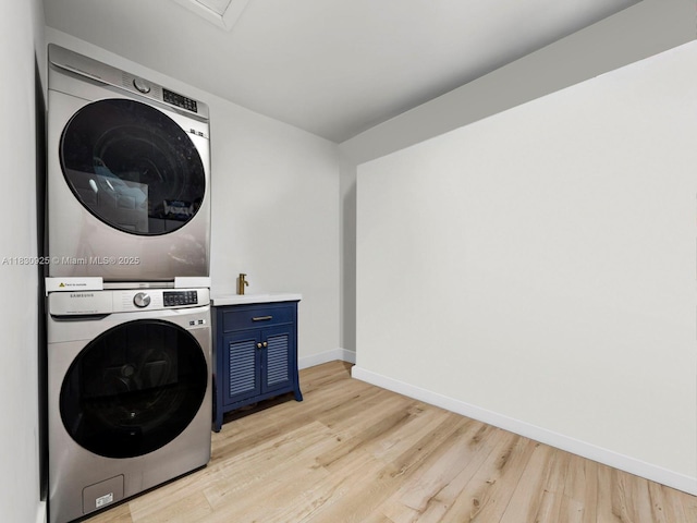 14913 SW 143rd Ct, Miami, FL 33186 - laundry area with estacked washer and dryer, light wood-style floors, and cabinet space
