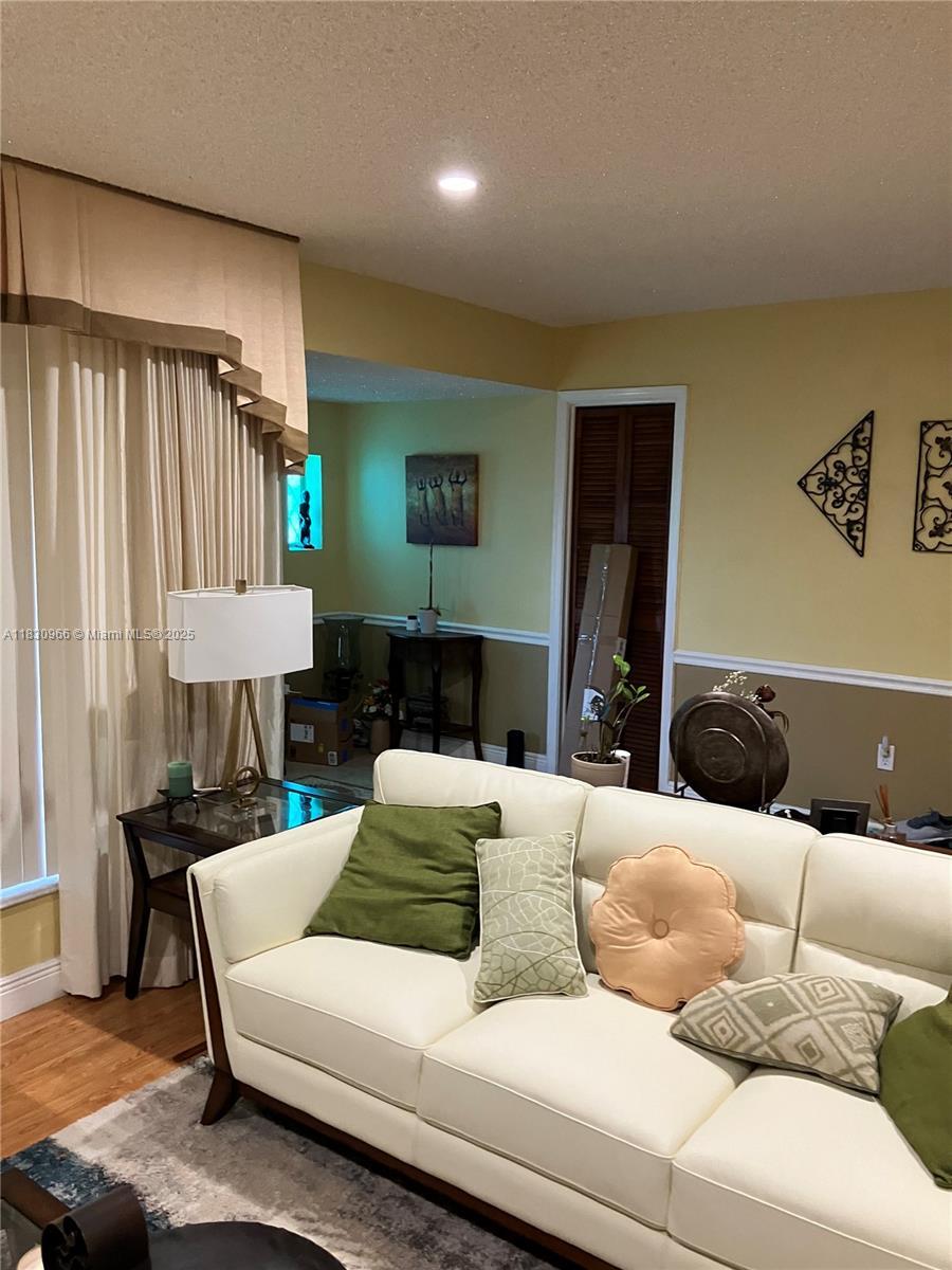 20950 N Miami Ave, Miami Gardens, FL 33169 - living room featuring a textured ceiling, wood finished floors, and recessed lighting