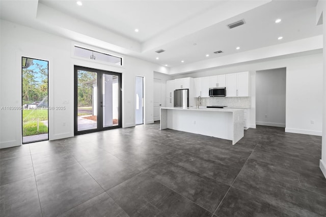 3324 NE 27, Naples, FL 34120 - unfurnished living room with recessed lighting, a raised ceiling, and concrete floors