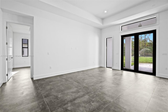 3324 NE 27, Naples, FL 34120 - spare room featuring concrete floors, a tray ceiling, and recessed lighting