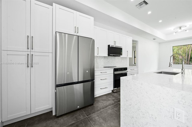 3324 NE 27, Naples, FL 34120 - kitchen with stainless steel appliances, light stone counters, white cabinetry, tasteful backsplash, and recessed lighting