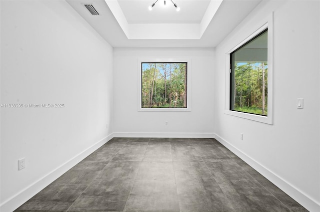 3324 NE 27, Naples, FL 34120 - unfurnished room with plenty of natural light, a tray ceiling, and concrete floors