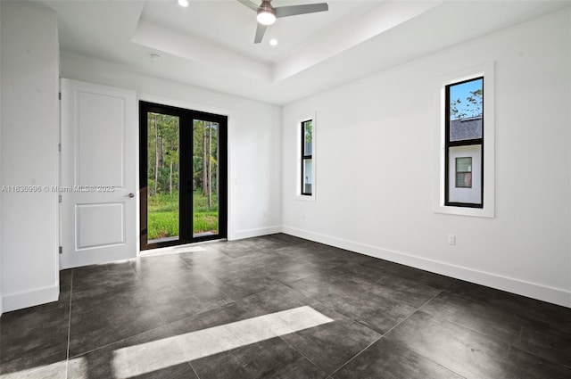 3324 NE 27, Naples, FL 34120 - empty room with healthy amount of natural light, a tray ceiling, recessed lighting, concrete floors, and ceiling fan