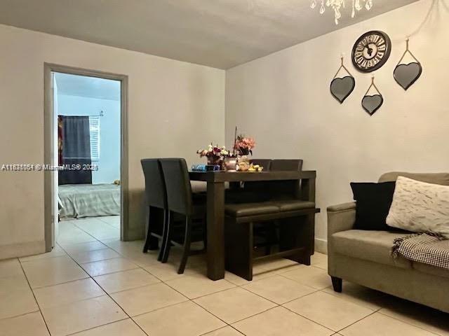 12890 NE 8th Ave Unit 102, North Miami, FL 33161 - dining room with light tile patterned floors and a chandelier
