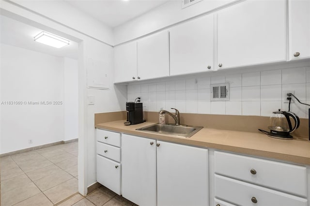 1200 W Ave Unit 1419, Miami Beach, FL 33139 - kitchen with white cabinets, backsplash, light tile patterned flooring, and light countertops