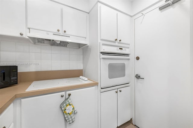 1200 W Ave Unit 1419, Miami Beach, FL 33139 - kitchen with white appliances, under cabinet range hood, decorative backsplash, white cabinetry, and light countertops