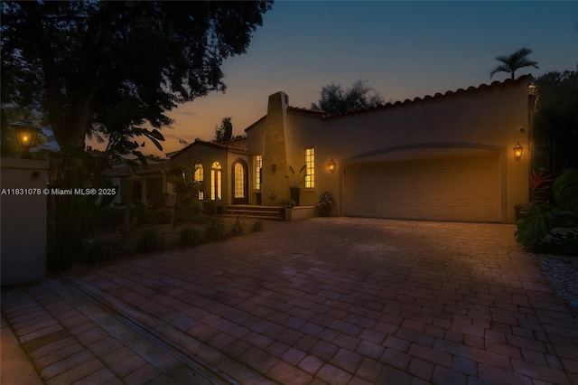 1320 Obispo Ave, Coral Gables, FL 33134 - mediterranean / spanish home with decorative driveway, a garage, stucco siding, and a tiled roof