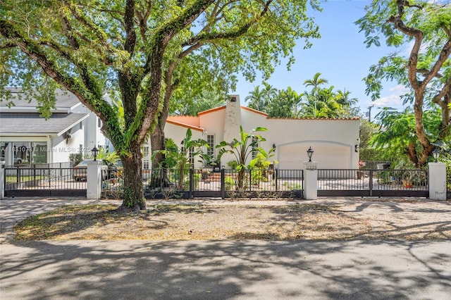 1320 Obispo Ave, Coral Gables, FL 33134 - view of front facade with a garage, stucco siding, a fenced front yard, and driveway