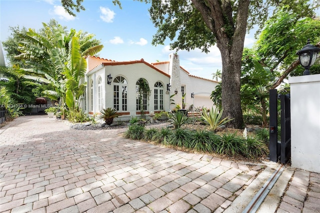1320 Obispo Ave, Coral Gables, FL 33134 - view of front of house with a tiled roof, stucco siding, a garage, and driveway