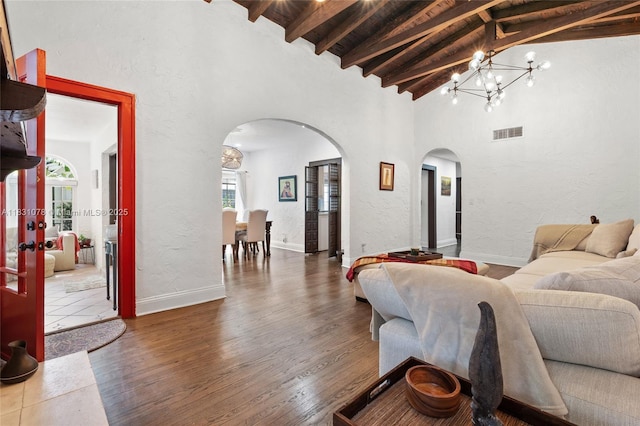 1320 Obispo Ave, Coral Gables, FL 33134 - living area with arched walkways, beamed ceiling, a chandelier, wood finished floors, and high vaulted ceiling