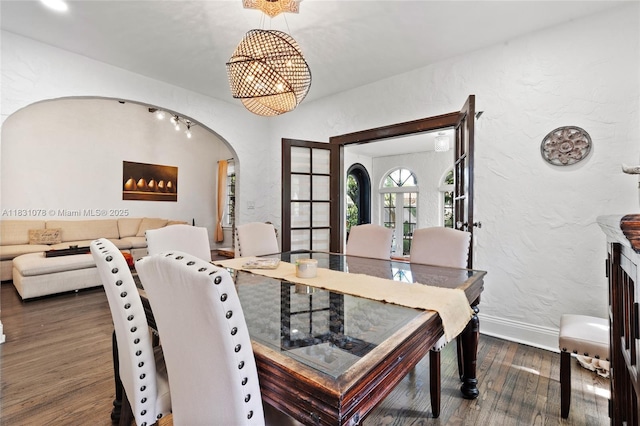 1320 Obispo Ave, Coral Gables, FL 33134 - dining space featuring wood finished floors, arched walkways, a textured wall, and a chandelier