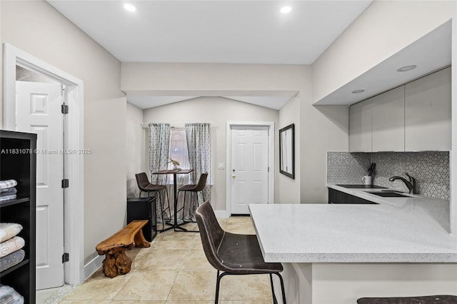 1320 Obispo Ave, Coral Gables, FL 33134 - kitchen featuring a breakfast bar, recessed lighting, tasteful backsplash, a peninsula, and light stone countertops