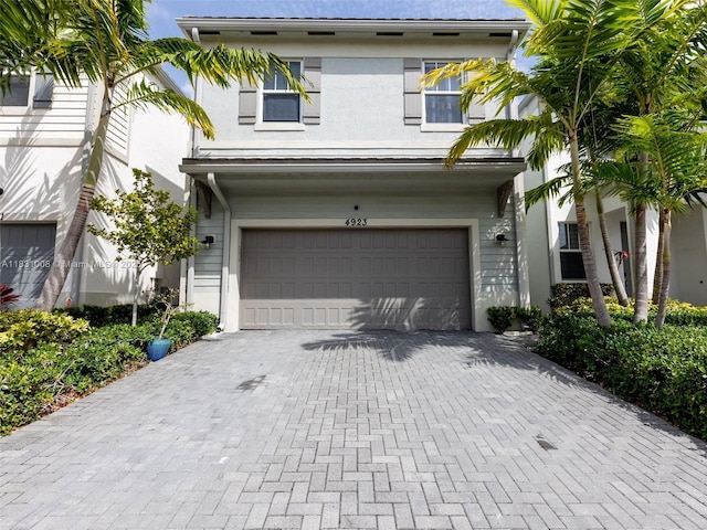4923 NW 48th Ter, Tamarac, FL 33319 - view of front of home with an attached garage, decorative driveway, and stucco siding