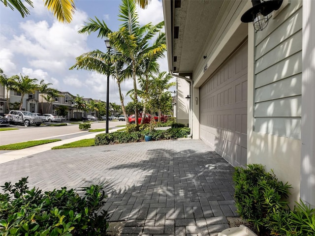 4923 NW 48th Ter, Tamarac, FL 33319 - view of patio with decorative driveway, a residential view, and a garage