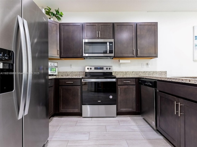 4923 NW 48th Ter, Tamarac, FL 33319 - kitchen with appliances with stainless steel finishes, dark brown cabinets, and light stone counters