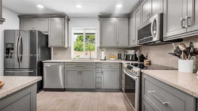 10401 NW 21st St, Pembroke Pines, FL 33026 - kitchen featuring stainless steel appliances, gray cabinetry, recessed lighting, decorative backsplash, and light stone counters