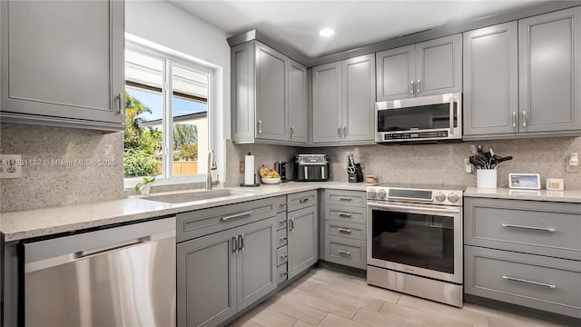 10401 NW 21st St, Pembroke Pines, FL 33026 - kitchen featuring stainless steel appliances, gray cabinets, tasteful backsplash, recessed lighting, and light stone countertops