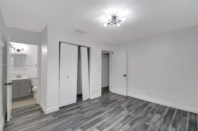 4917 SW 43rd Ter, Dania Beach, FL 33314 - unfurnished bedroom with wood finished floors, a closet, and ensuite bath