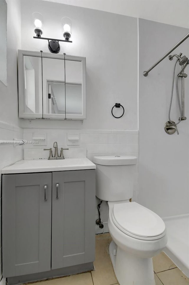 4917 SW 43rd Ter, Dania Beach, FL 33314 - bathroom featuring tile patterned floors, a shower, vanity, a wainscoted wall, and tile walls