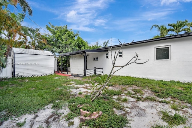 4917 SW 43rd Ter, Dania Beach, FL 33314 - rear view of house with a storage unit and a yard