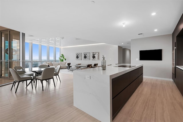 851 NE 1st Ave Unit Ph4912, Miami, FL 33132 - kitchen with modern cabinets, open floor plan, black electric cooktop, an island with sink, and light wood-style floors