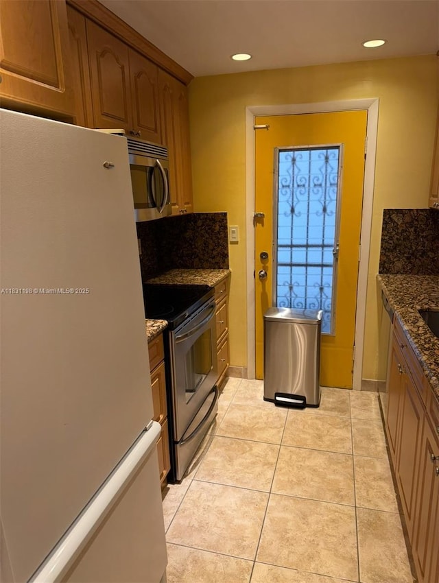 11685 Canal Dr Unit 303, North Miami, FL 33181 - kitchen featuring appliances with stainless steel finishes, recessed lighting, dark stone counters, light tile patterned flooring, and brown cabinets