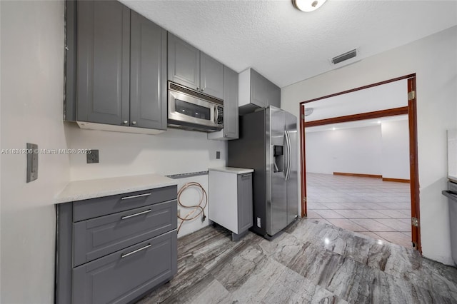 15235 SW 99th Ct, Miami, FL 33157 - kitchen featuring appliances with stainless steel finishes, gray cabinets, light countertops, a textured ceiling, and light tile patterned flooring