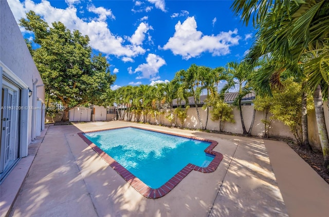 15235 SW 99th Ct, Miami, FL 33157 - view of swimming pool with a patio area, a fenced backyard, and a storage unit