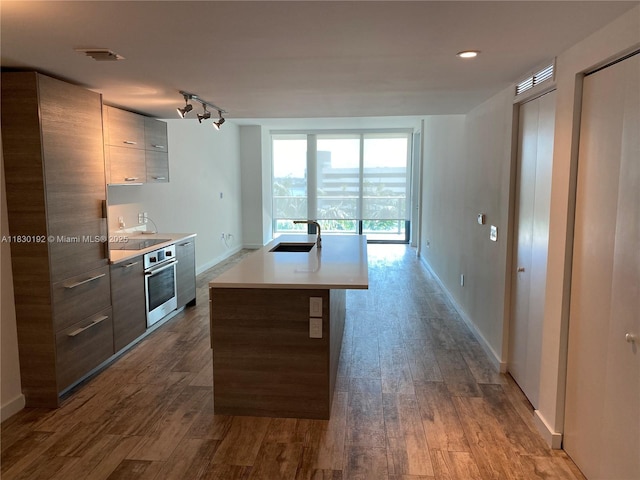 650 NE 32nd St Unit 802, Miami, FL 33137 - kitchen featuring modern cabinets, appliances with stainless steel finishes, dark wood finished floors, light countertops, and a kitchen island with sink