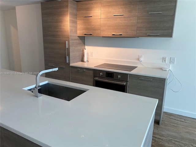 650 NE 32nd St Unit 802, Miami, FL 33137 - kitchen with oven, black electric cooktop, modern cabinets, and wood finished floors