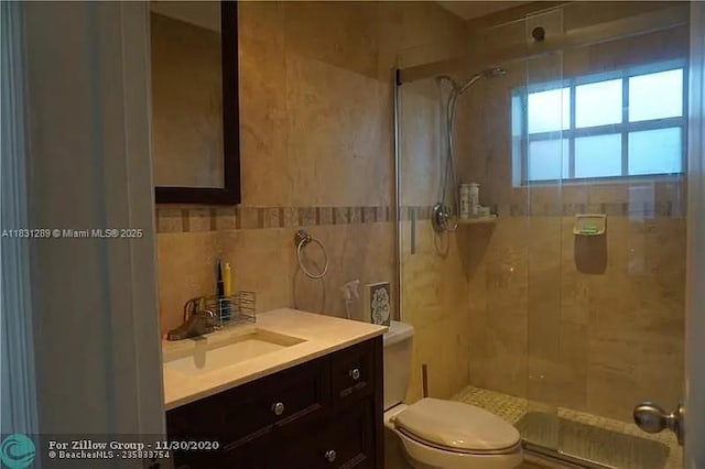 771 E 35th St, Hialeah, FL 33013 - full bathroom featuring a stall shower, vanity, tile walls, and decorative backsplash