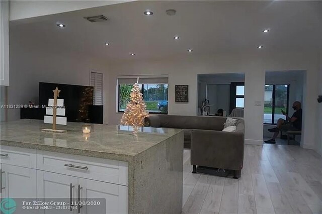 771 E 35th St, Hialeah, FL 33013 - kitchen with open floor plan, light stone countertops, white cabinets, light wood-style flooring, and recessed lighting