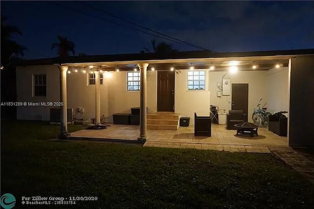 771 E 35th St, Hialeah, FL 33013 - back of house at twilight with an outdoor fire pit, stucco siding, a patio area, and entry steps