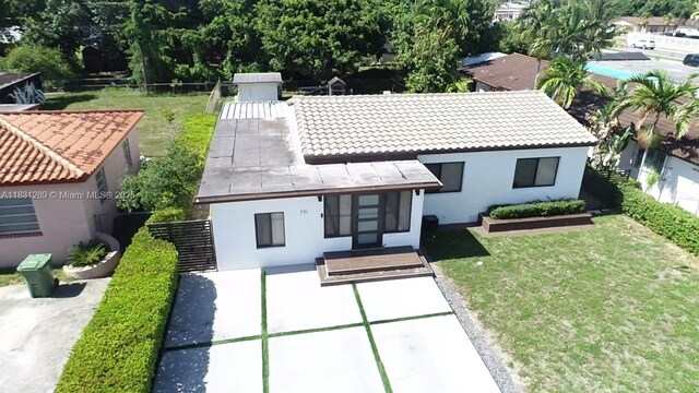 771 E 35th St, Hialeah, FL 33013 - view of front facade featuring stucco siding, a front yard, and a tile roof