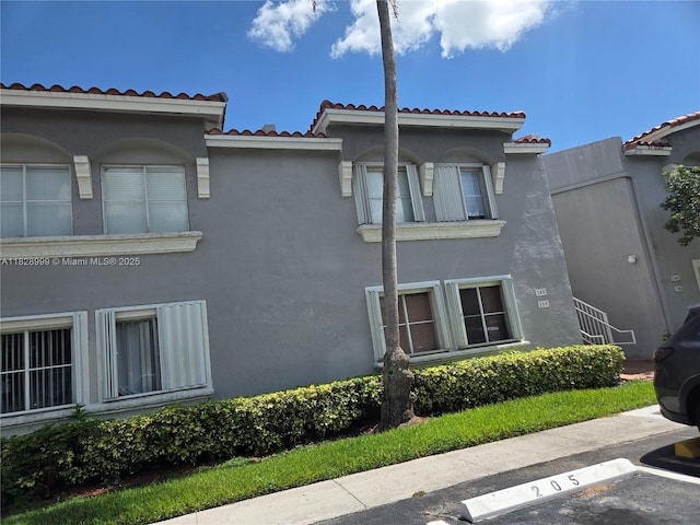 4720 NW 114th Ave Unit 206, Doral, FL 33178 - view of property exterior with a tiled roof, stucco siding, and uncovered parking