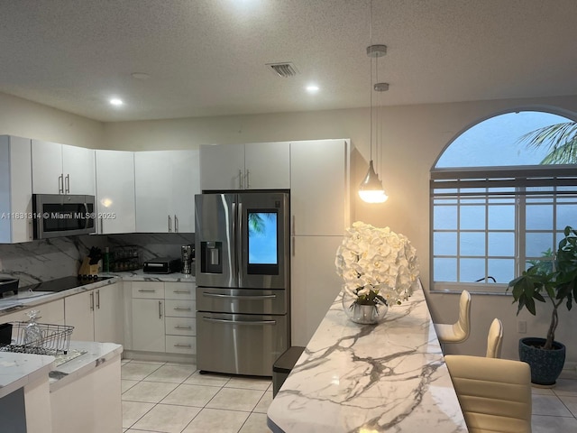 15271 NW 6th Ct, Pembroke Pines, FL 33028 - kitchen featuring stainless steel appliances, decorative backsplash, light tile patterned floors, pendant lighting, and a textured ceiling