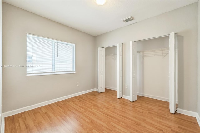 3156 NE 4th St, Homestead, FL 33033 - unfurnished bedroom featuring two closets and light wood-type flooring